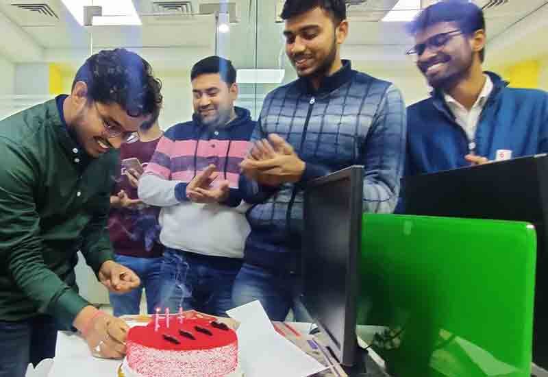 Weblytic Labs team celebrating a colleague’s birthday with cake, smiles, and team cheer.