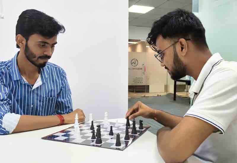 Weblytic Labs employees playing chess during Chess Day event